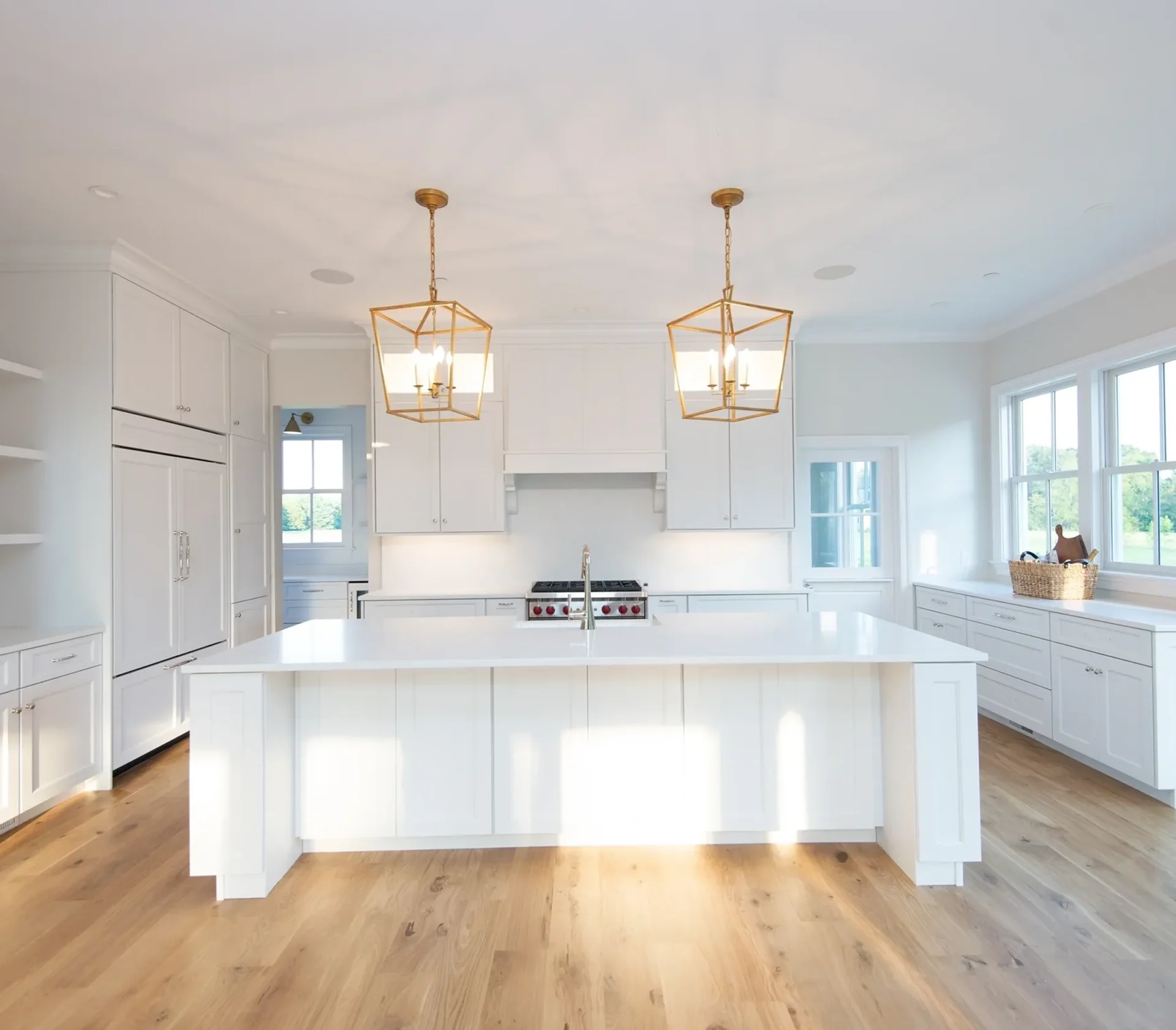 Modern white kitchen with island and lighting.