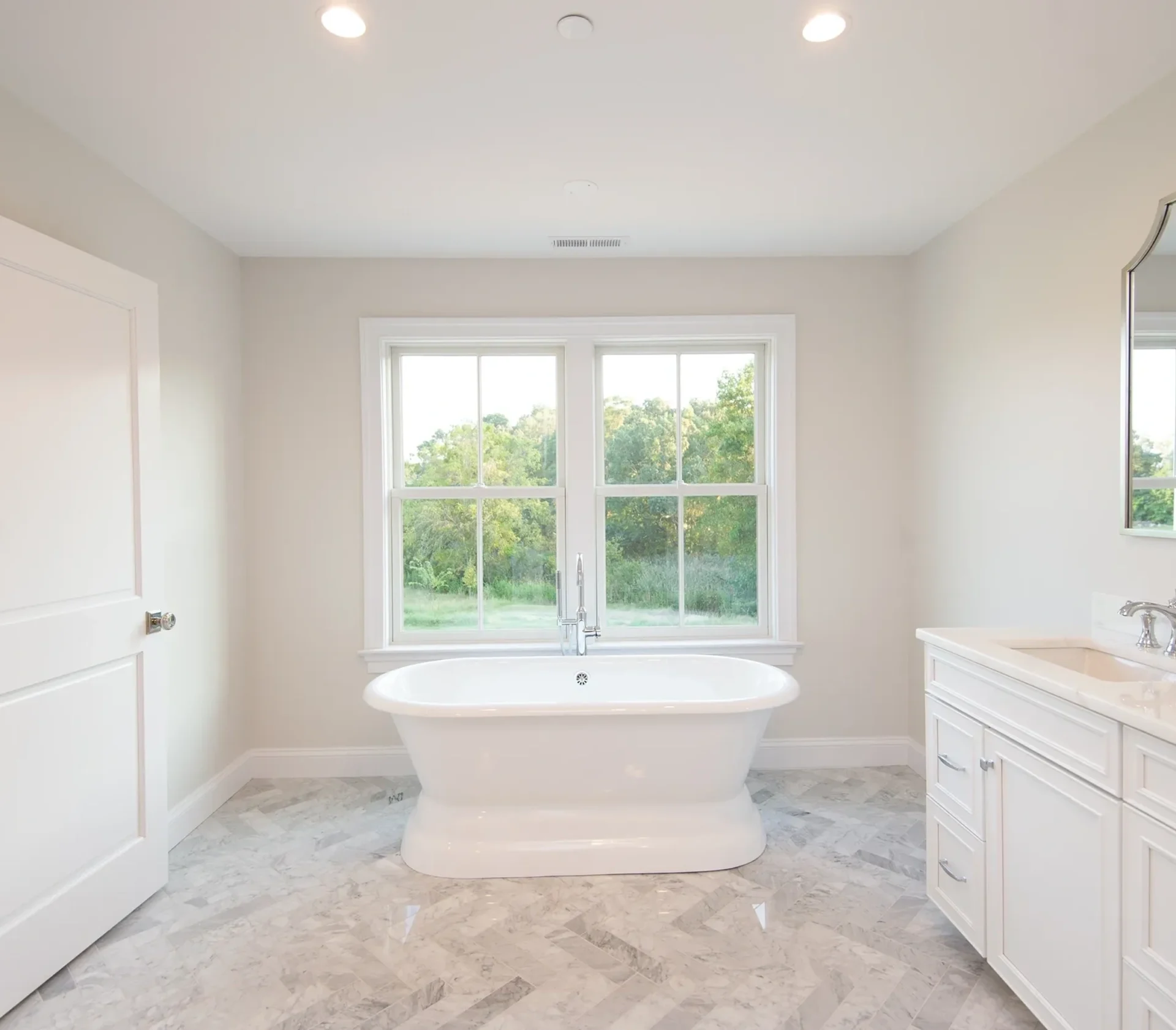 Modern bathroom with freestanding bathtub and window.