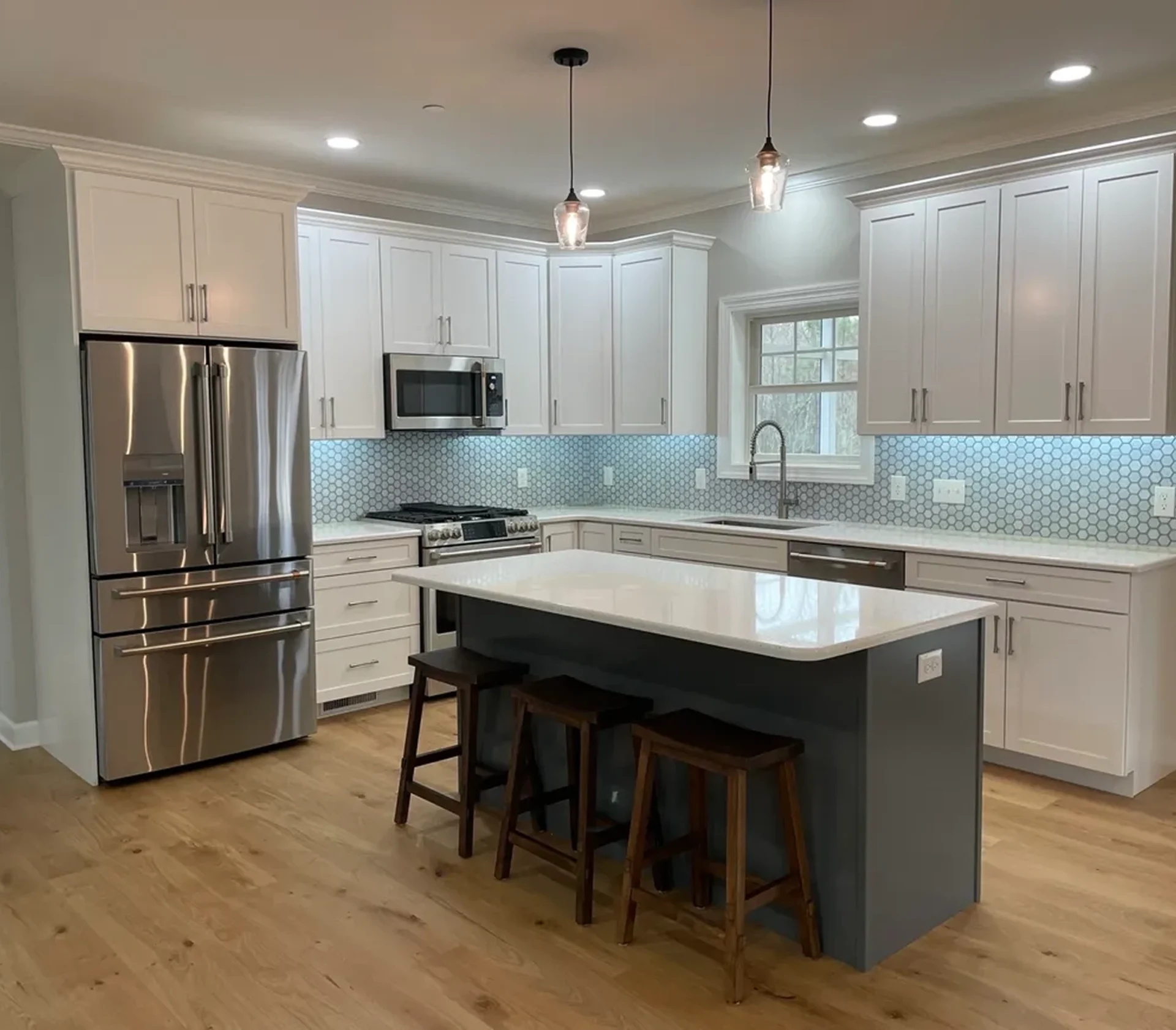 Modern kitchen with island and pendant lights.