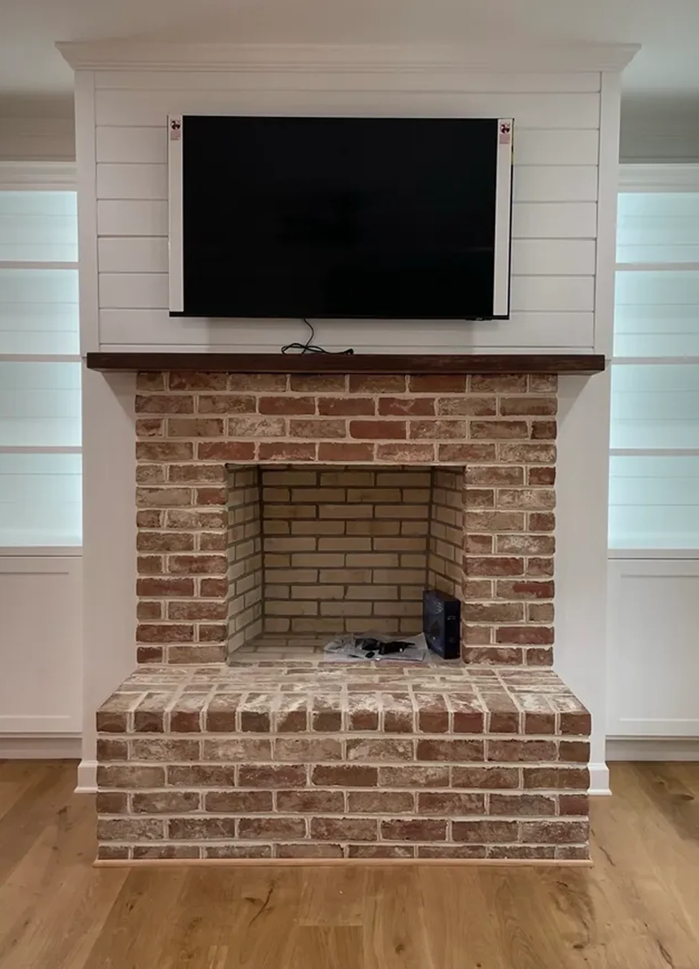 Brick fireplace with TV above mantel.