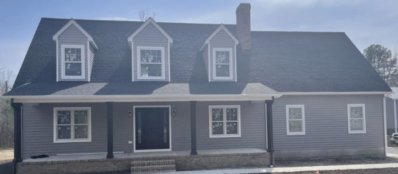 Two-story gray house with white trim and a covered front porch.